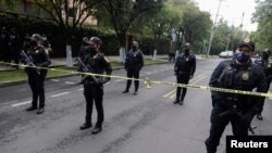 Policías vigilan cerca del lugar donde ocurrió el intento de asesinato al jefe de policía de la Ciudad de México, Omar García Harfuch, el 26 de junio de 2020.