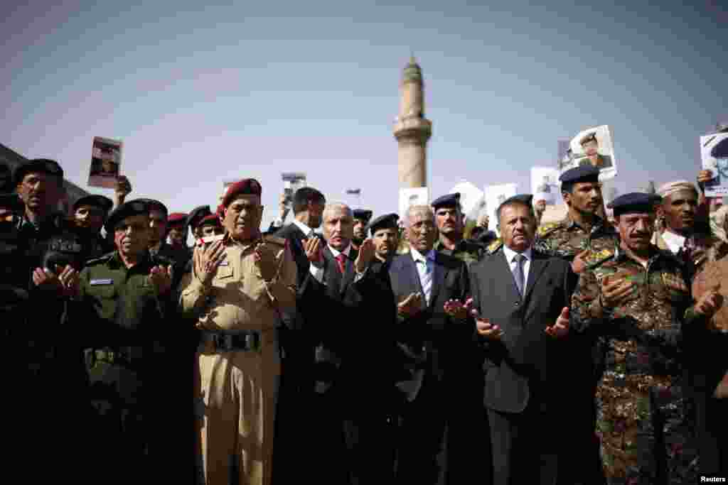 Yemeni military and police officials recite prayers during the funeral procession of police troopers, killed in Saturday's attack on an intelligence service headquarters, in Sanaa August 20, 2012. 