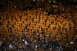 FILE - People keep social distancing amid concerns over the country's coronavirus outbreak, during a protest against Prime Minister Benjamin Netanyahu in Tel Aviv, Israel, April 19, 2020.