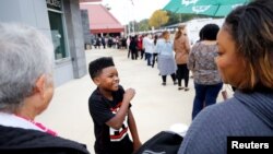 Masada Hart, 9, waits in line with his mother before Oprah Winfrey takes part in a town hall meeting with Democratic gubernatorial candidate Stacey Abrams ahead of the mid-term election in Marietta, Georgia, U.S., Nov. 1, 2018. 
