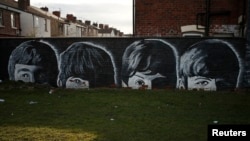 FILE - A mural of the Beatles is seen painted on the end of a row of terraced houses in Liverpool, northern England, Feb. 18, 2015. 