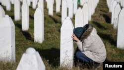 A woman visits a grave of her family members in the memorial center Potocari near Srebrenica, Bosnia and Herzegovina, after the court proceedings of former Bosnian Serb general Ratko Mladic, Nov. 22, 2017.