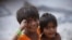 Two Indian girls react to the camera as they play on a street outside their roadside shanty, on International Day of the Girl Child in Hyderabad, India, Oct. 11, 2012.