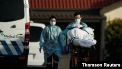 A patient is removed from an aged care facility experiencing an outbreak of COVID-19 in Melbourne