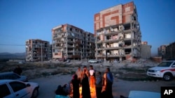 Sobrevivientes del terremoto del domingo por la noche en Irán se abrigan frente a una hoguera frente a edificios destruidos en la ciudad de Sarpol-e-Zahab, en el occidente del país. Foto provista por la Agencia de Noticias de Estudiantes Iraníes, ISNA. Nov. 13, 2017.