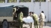 Tanzanian security forces remove the slain body of an attacker who was wielding an assault rifle, outside the French embassy in the Salenda area of Dar es Salaam, Tanzania, Aug. 25, 2021.