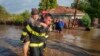 A rescuer carries a woman in Pechea, Romania, on Sept. 14, 2024, after torrential rainstorms left scores of people stranded in flooded areas. (Romanian Emergency Services via AP)