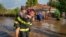 A rescuer carries a woman in Pechea, Romania, on Sept. 14, 2024, after torrential rainstorms left scores of people stranded in flooded areas. (Romanian Emergency Services via AP)