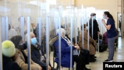 FILE - Seniors sit in a waiting room after receiving their vaccines against the coronavirus disease (COVID-19) in a clinic as Quebec begins vaccinations for seniors over 85 in Laval, Quebec, Canada, Feb. 25, 2021.