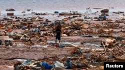 Un niño lleva una lámina para techos en la playa después del paso del ciclón Chido, en Passamainty, Mayotte, Francia, el 20 de diciembre de 2024.