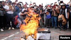 Demonstrators take photographs with their mobile phones during the burning of a mock coffin dedicated to Peru's President Dina Boluarte, in Cuzco, Peru Dec. 14, 2022.