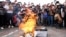 Demonstrators take photographs with their mobile phones during the burning of a mock coffin dedicated to Peru's President Dina Boluarte, in Cuzco, Peru Dec. 14, 2022.