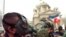 Serbia, Belgrade, Two opposition supporters kiss while wearing gas masks after clashes