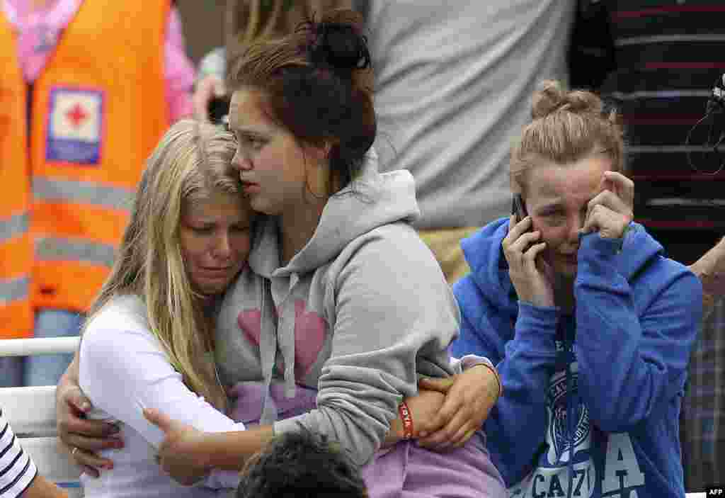 Survivors react as Norwegian King Harald and Queen Sonja (not seen) arrive to comfort them outside a hotel in Sundvollen, northwest of Oslo July 23, 2011. The king and queen have arrived at the hotel where survivors and family members are staying after 84