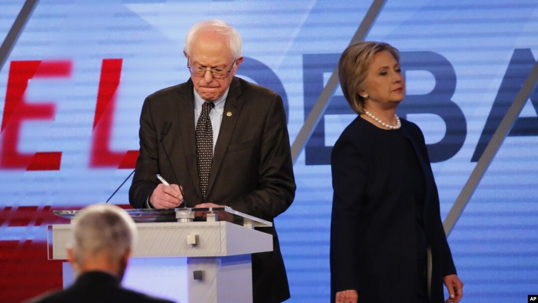 Democratic presidential candidate, Hillary Clinton enters the stage after a break as Democratic presidential candidate, Sen. Bernie Sanders, I-Vt, makes notes, March 9, 2016.