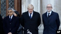 Britain's Prime Minister Boris Johnson, center, Labour Party leader Jeremy Corbyn, right, and Mayor of London Sadiq Khan take part in a vigil at Guildhall Yard in London, Dec. 2, 2019.