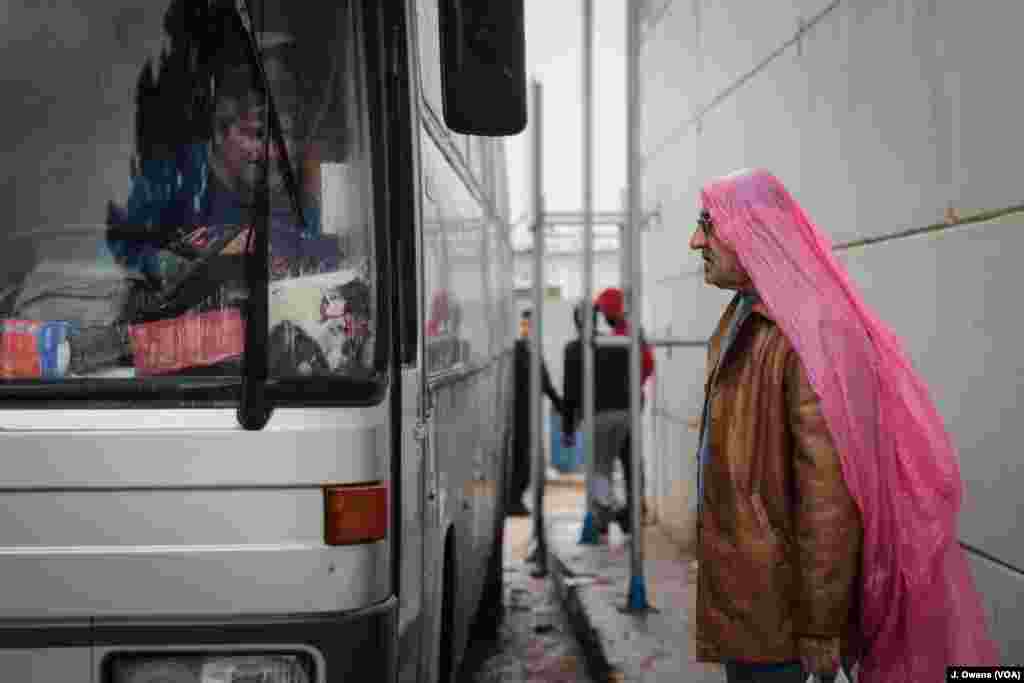 Seorang pria siap naik bus yang akan meninggalkan Kamp Vial di Chios.