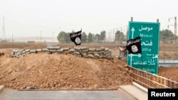 Islamic State flags flutter on the Mullah Abdullah bridge in southern Kirkuk, Iraq, Sept. 29, 2014.