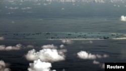 FILE - An aerial photo taken though a glass window of a Philippine military plane shows the alleged ongoing land reclamation by China in the Spratly Islands in the South China Sea, west of Palawan, Philippines.