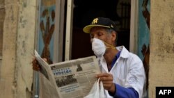 A man reads a newspaper as he wears a face mask in Havana, on March 12, 2020 as the world battles the outbreak of the new coronavirus, COVID-19.