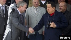 Venezuela's President Hugo Chavez (R) and First Deputy Prime Minister of Belarus Vladimir Semashko shake hands after their meeting at Miraflores Palace in Caracas, Venezuela, June 2, 2012.