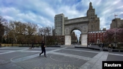 People walk around Washington square park as the coronavirus disease (COVID-19) outbreak continues in New York, U.S., March 22, 2020. 
