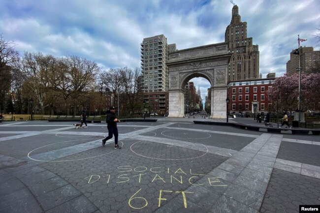 Gente camina alrededor del parque Washington Square en Nueva York el 22 de marzo de 2020, mientras la pandemia de COVID-19 continúa afectando la ciudad.