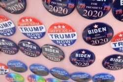FILE - Biden for President buttons are for sale beside "Impeach Trump Now!" buttons as U.S. Democratic presidential candidate and former Vice President Joe Biden meets union workers at the Teamsters Local 249 hall in Pittsburgh, April 29, 2019.