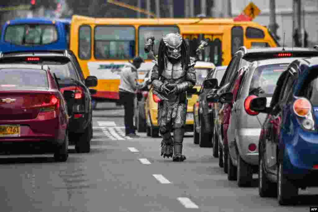 A man in a predator costume walks along an avenue in Bogota, Colombia, March 3, 2021.
