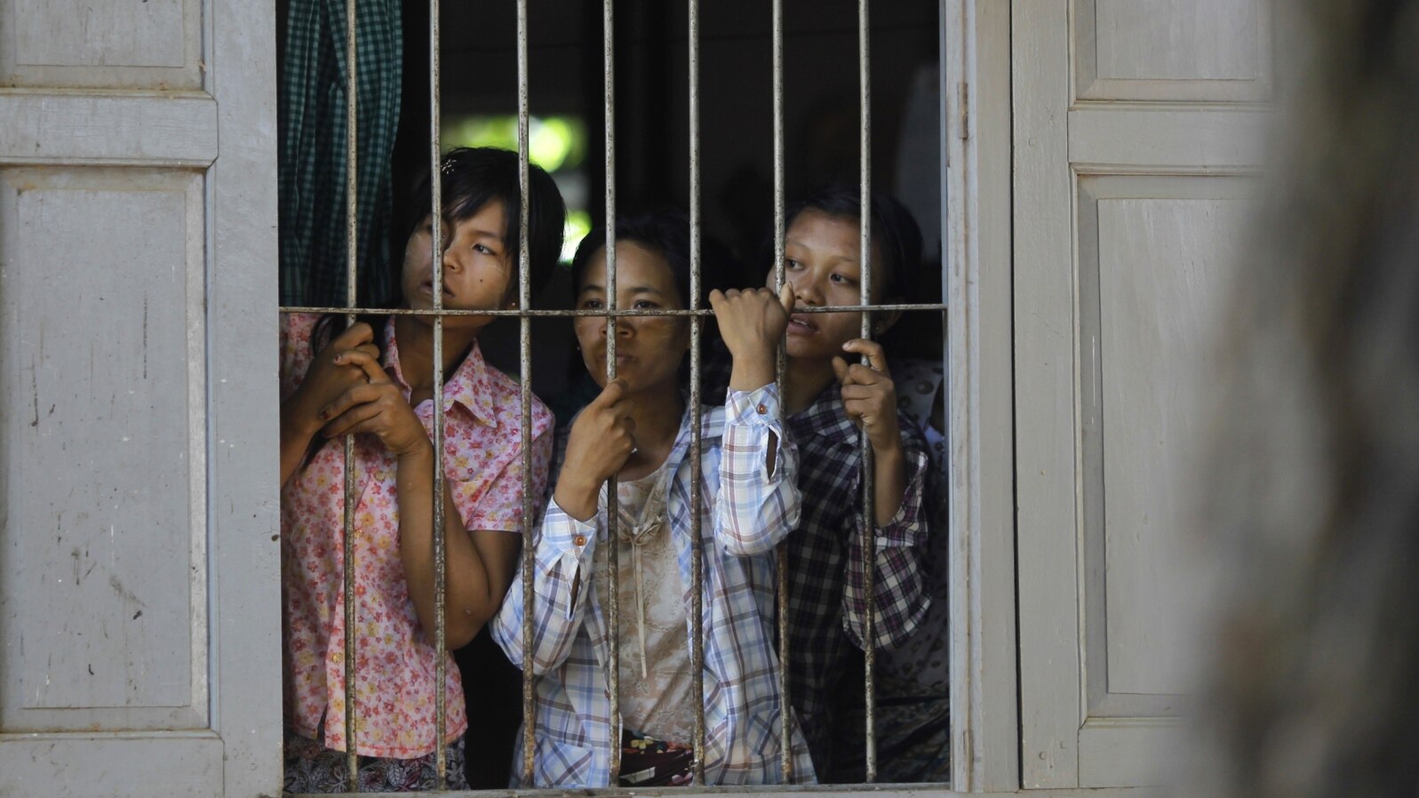Burmese farmers look at police from inside a monastery in protest against the seizing of farmland across 26 villages for a copper mine project in Sarlingyi Township, September 12, 2012. 