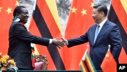 FILE: Zimbabwean President Emmerson Mnangagwa, left, shakes hands with Chinese President Xi Jinping as they pose for the media after a signing ceremony at the Great Hall of the People in Beijing, China.