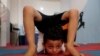 A Palestinian boy performs during a yoga and flexibility class on International Yoga Day in a club in Gaza City.