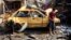 An Iraqi boy stands near a destroyed car at the scene of a car bomb attack in Baghdad's northern Kazimyah neighborhood, Feb. 8, 2013.