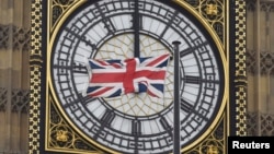 A British Union flag flutters in front of one of the clock faces of the 'Big Ben' clocktower of The Houses of Parliament in central London, Feb. 22 , 2016