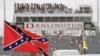 FILE - In this Sept. 5, 2015, file photo, a Confederate flag flies before a NASCAR race at Darlington Raceway in Darlington, S.C. Bubba Wallace, the only African-American driver in NASCAR, calls for a ban on the Confederate flag in the sport that is deepl