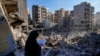 A woman reads the Quran at the site of the assassination of Hezbollah leader Hassan Nasrallah in Beirut's southern suburbs, Sept. 29, 2024.