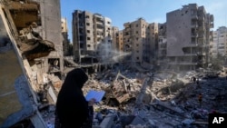 A woman reads the Quran at the site of the assassination of Hezbollah leader Hassan Nasrallah in Beirut's southern suburbs, Sept. 29, 2024.