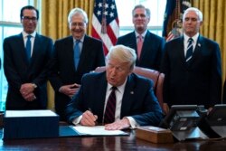 ABD Başkanı Donald Trump Kongre tarafından kabul edilen ekonomik yardım paketini imzalarken, 27 Mart 2020.