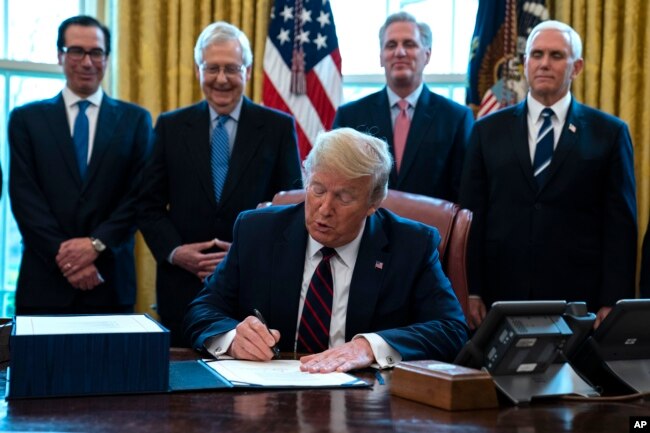 ABD Başkanı Donald Trump Kongre tarafından kabul edilen ekonomik yardım paketini imzalarken, 27 Mart 2020.