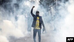 Um manifestante canta slogans rodeado de gás lacrimogéneo durante uma manifestação contra o aumento dos impostos, enquanto os deputados votam a Lei das Finanças 2024 no centro de Nairoibi, a 20 de junho de 2024.