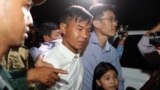 Two former Radio Free Asia reporters Uon Chhin, center, and Yeang Socheamet, right, hold together as they walk outside the main prison of Prey Sar at the outskirt of Phnom Penh, Cambodia, Tuesday, Aug. 21, 2018. Two Cambodian journalists who had worked fo