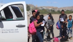 In this April 2019, frame from video, migrants turn themselves in to border agents in El Paso, Texas, after crossing the US - Mexico border.
