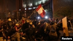 Un manifestante porta una bandera de Perú en medio de las protestas y enfrentamientos con la policía en Lima, el 14 de noviembre de 2020.