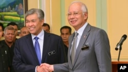 Malaysia's Prime Minister Najib Razak, right, shakes hands with his newly appointed Deputy Prime Minister Ahmad Zahid Hamidi after addressing a press conference at the prime minister's office in Putrajaya, Malaysia, July, 28, 2015.