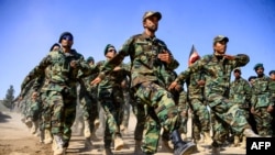 FILE - Afghan National Army soldiers march during a ceremony at a military base in the Guzara district of Herat province, Oct. 11, 2020. 