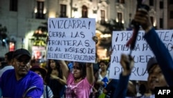 Una mujer sostiene un cartel que dice "Vizcarra, cierra las fronteras. No a la entrada de criminales venezolanos", refiriéndose al presidente peruano Martin Vizcarra, durante una protesta contra la migración venezolana en la plaza San Martín en Lima, el 25 de febrero de 2020.