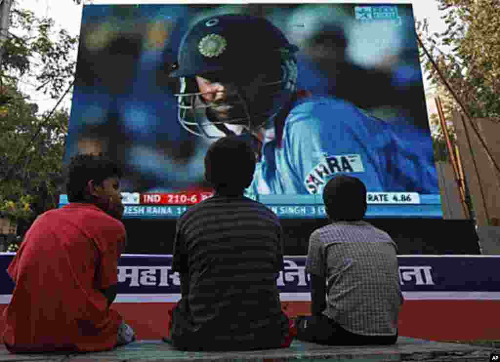Children watch the ICC Cricket World Cup semi-final match between India and Pakistan being played at Mohali on a big screen in Mumbai, March 30, 2011.