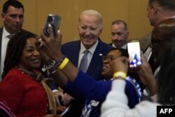 FILE - US President Joe Biden (C) takes pictures with attendees as he attends the Brookland Baptist Banquet Center for their “Sunday Lunch” in West Columbia, South Carolina, on January 28, 2024.