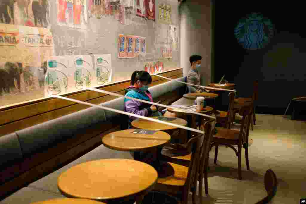 Tables and chairs are taped for the social distancing law enforcement to help curb the spread of the coronavirus at a Starbucks coffee shop in Hong Kong.