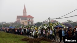 Villagers and relatives of John Hoang Van Tiep and John Nguyen Van Hung, who were found dead in the back of a British truck last month, attend their funeral at the village in Nghe An province, Vietnam, Nov. 28, 2019.